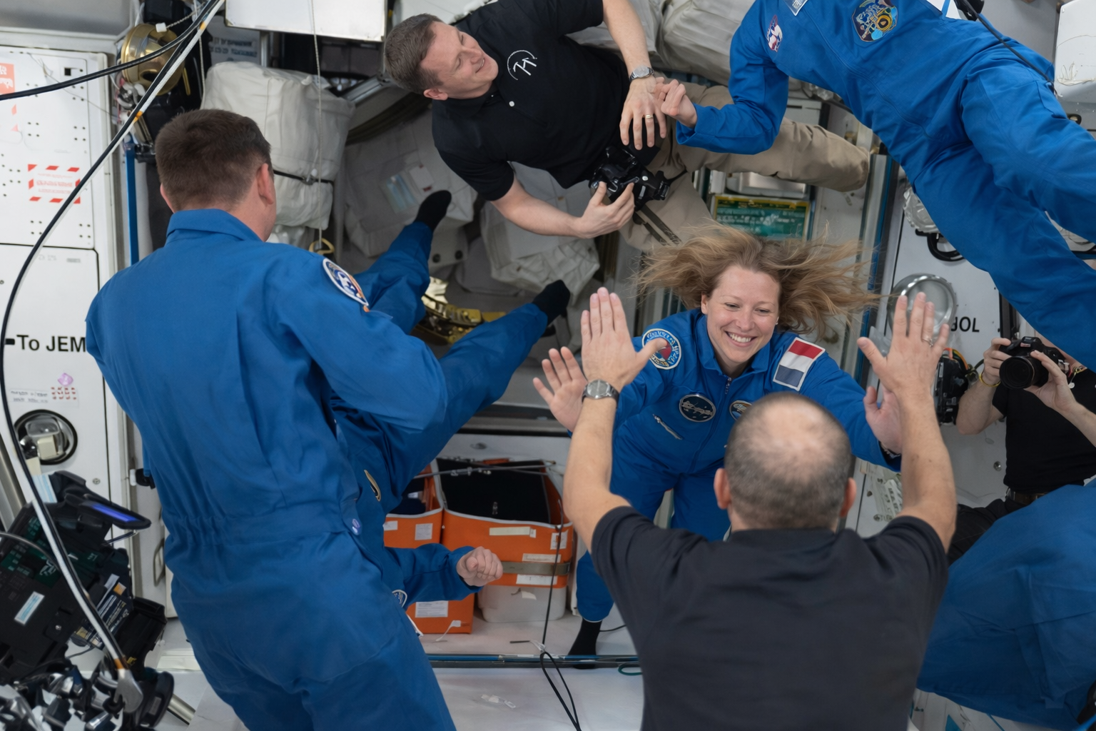 astronauts greet each other in space